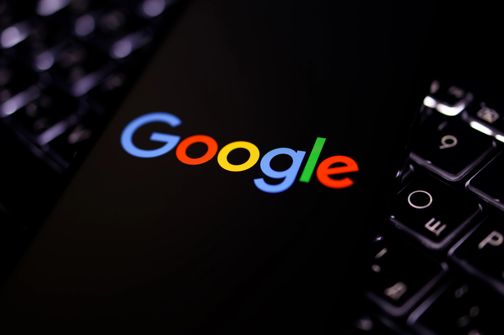 Kherson reg, Ukraine on September 19, 2024 Illustration photo of close-up Google logo displayed on a screen of smartphone laying on the illuminated laptop keyboard — Stock Editorial Photography