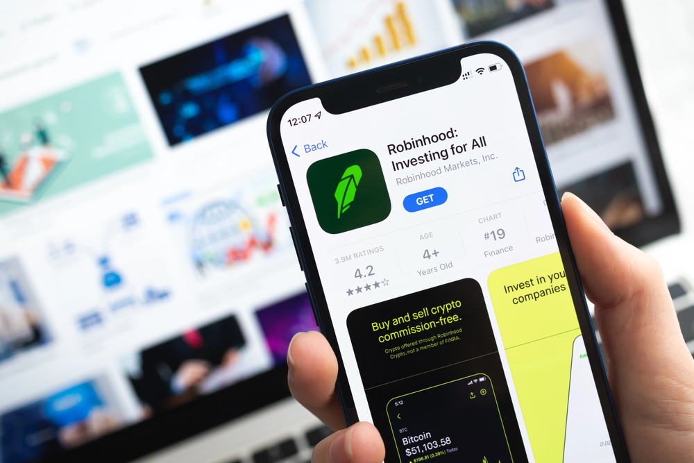 Poltava, Ukraine - April 5, 2022: Robinhood Investing app icon. Hand with mobile phone with application. Mobile banking and investment concept - Stock Editorial Photography