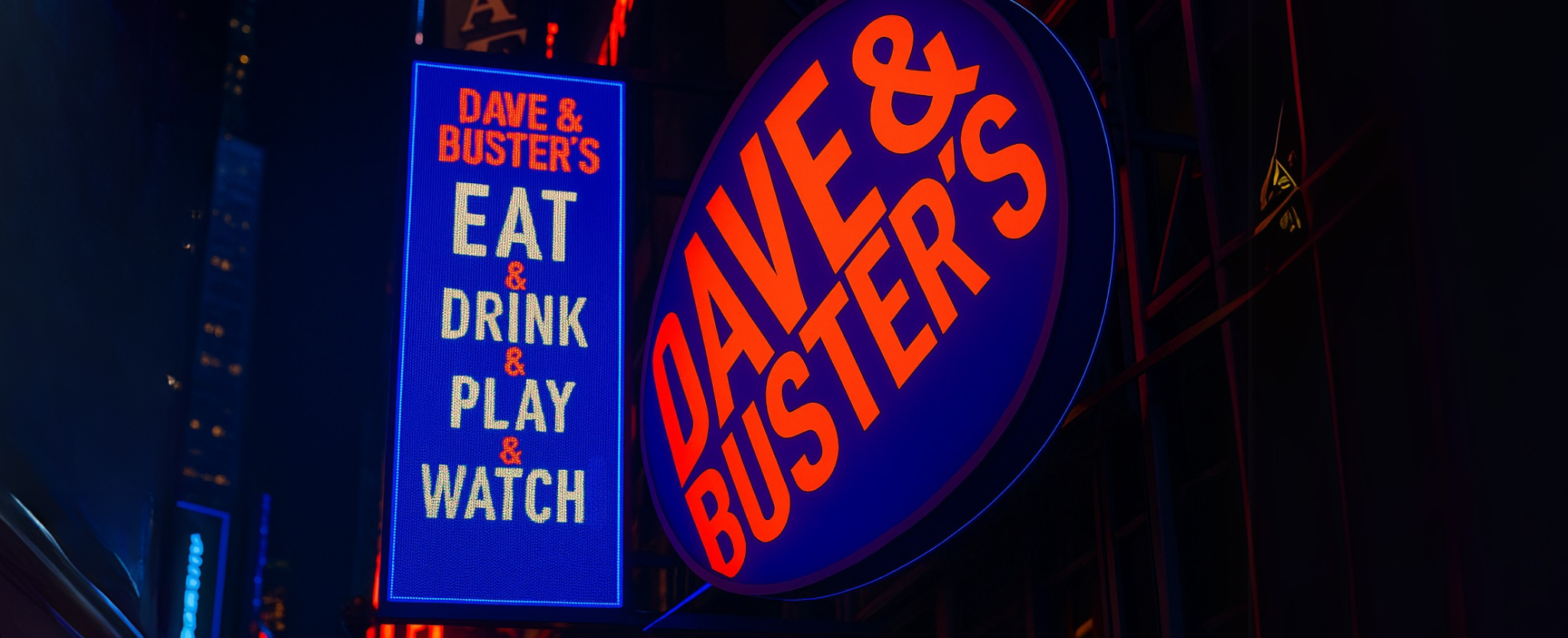 Dave & Buster's restaurant sign NYC - This image is an original composition by MarketBeat using licensed and editorial elements. Not for redistribution or reuse.