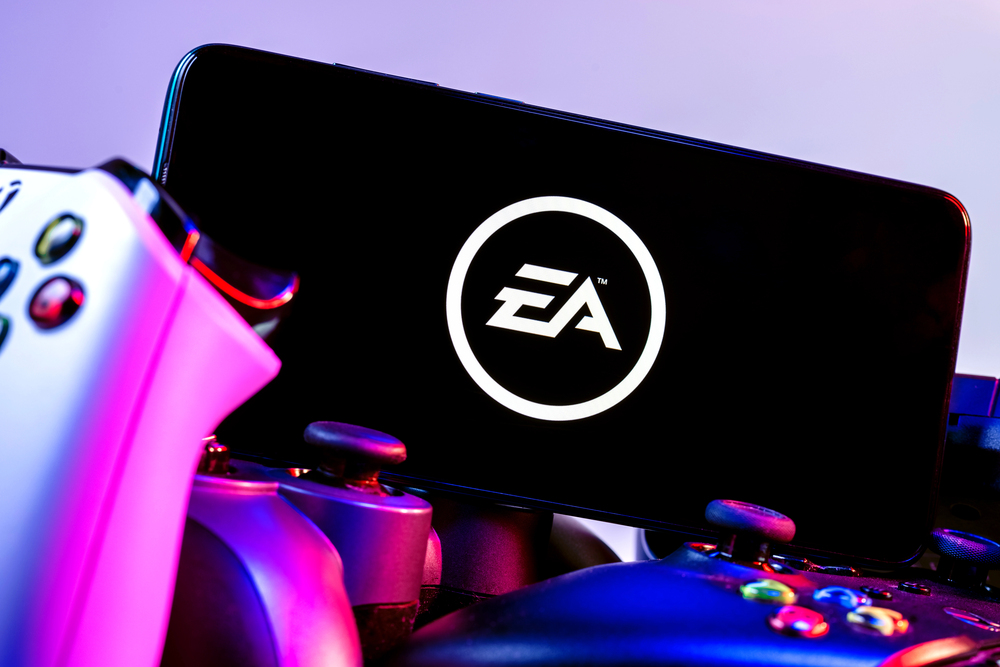 Kazan, Russia - August 14, 2021: Electronic Arts Inc. is an American video game company. A smartphone with the Electronic Arts logo on the screen on the pile of the gamepads. — Stock Editorial Photography