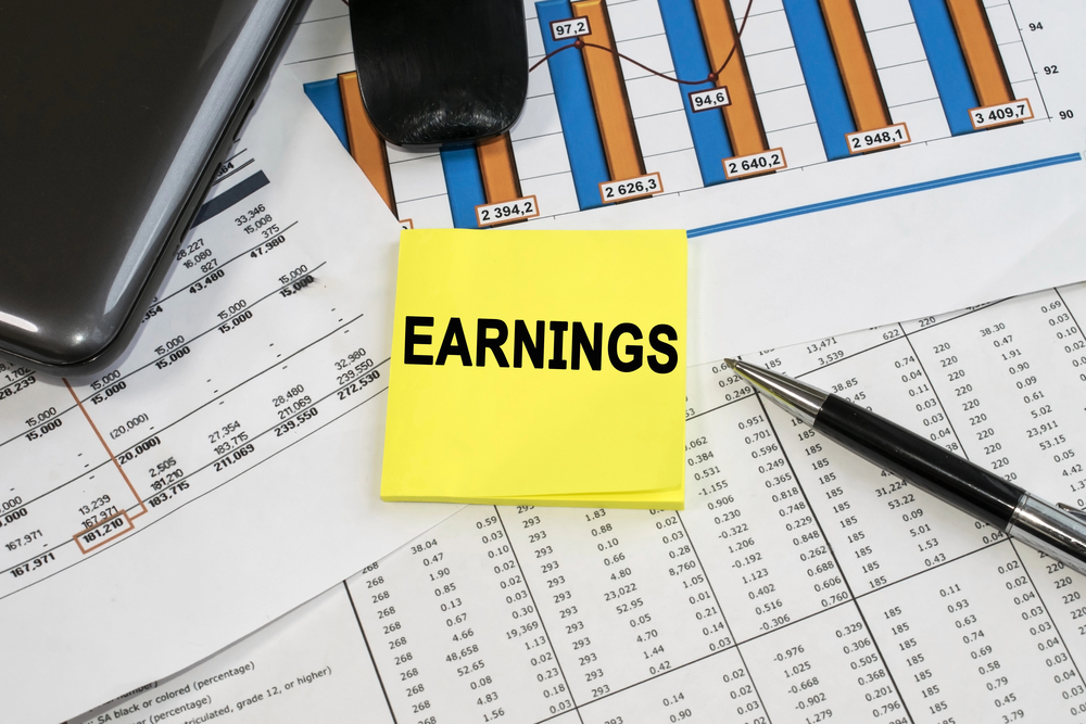 On documents with a color chart and numbers near the computer mouse is a yellow sticker on which the word profit is written. Business and financial concept - stock image