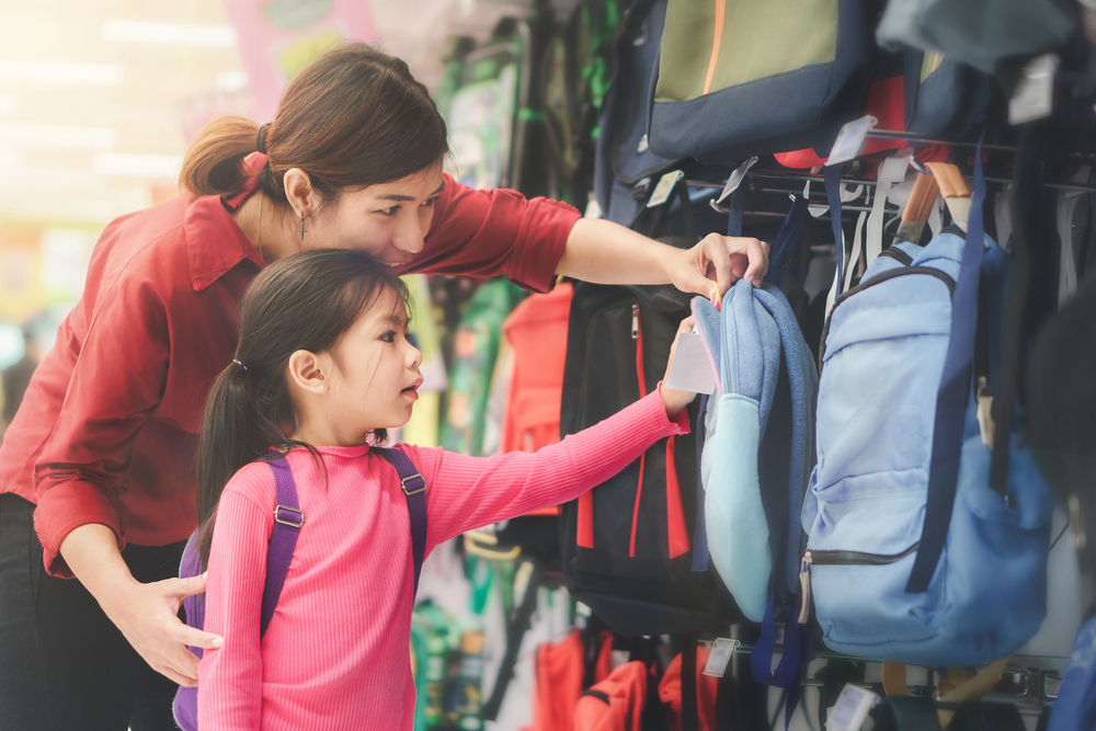 Back to school concept, Young asian mother or parent and little girl kid or cute pupil buying school satchel or bag in store, Selective focus — Photo