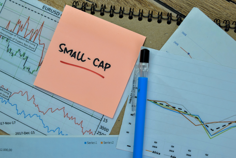 Small-cap write on sticky notes isolated on wooden table.
