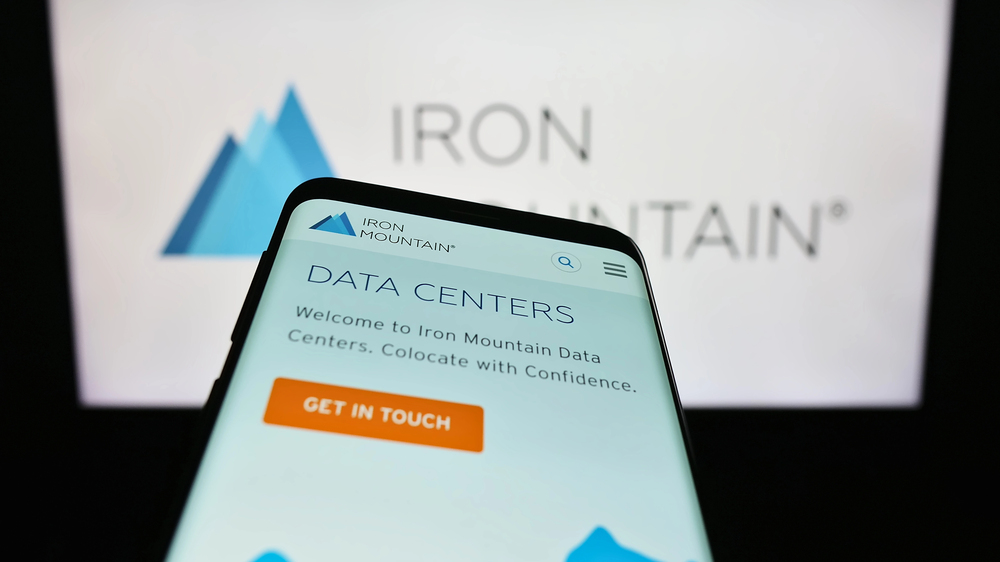 mobile phone with website of us company iron mountain inc. on screen in front of business logo