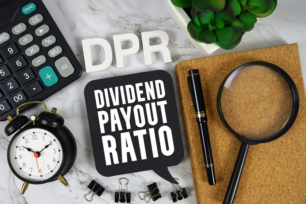 DPR Dividend Payout Ratio text with Calculator, alarm clock and magnifying glass on marble background