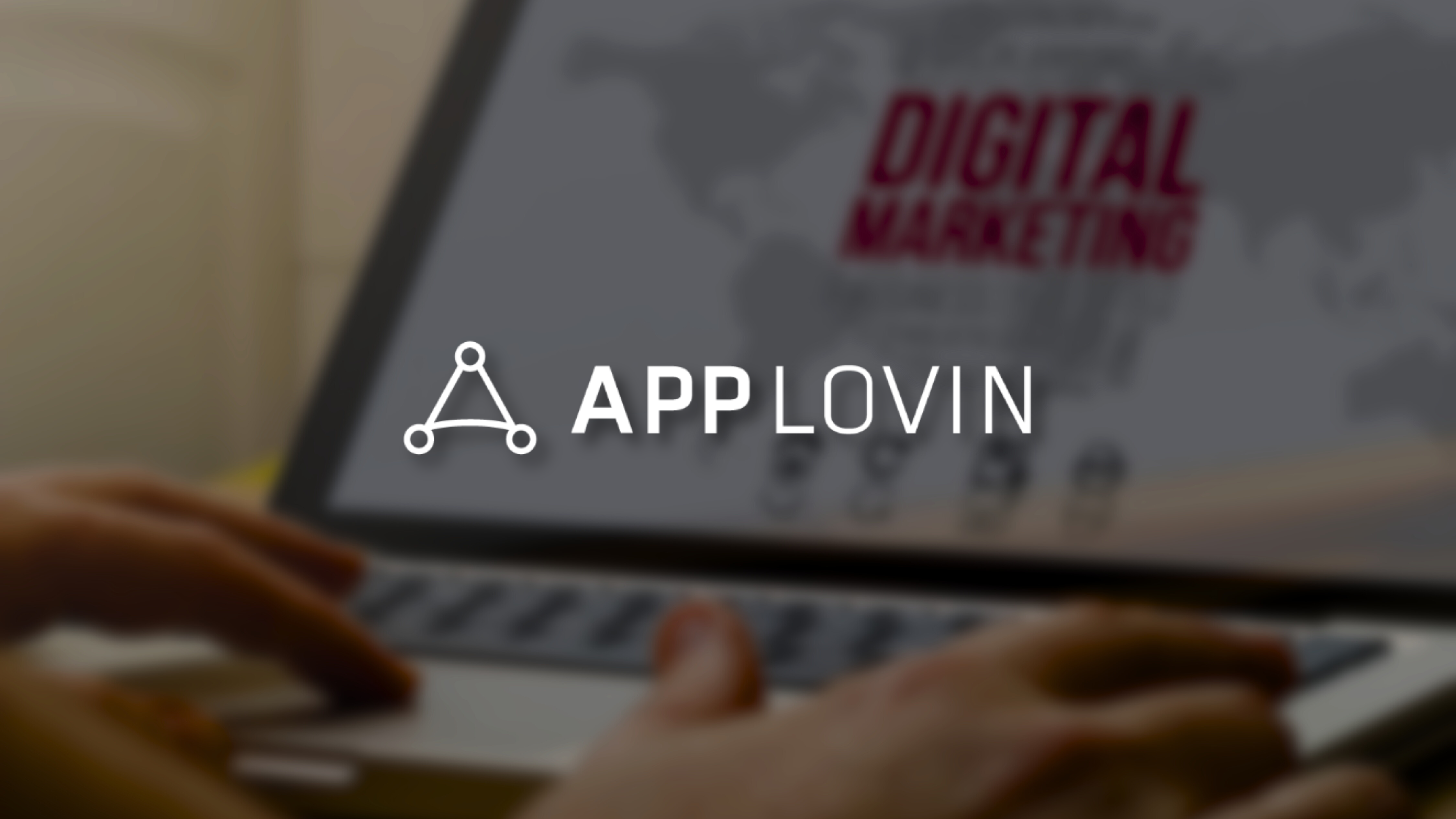 AppLovin logo over digital marketing platform on laptop screen