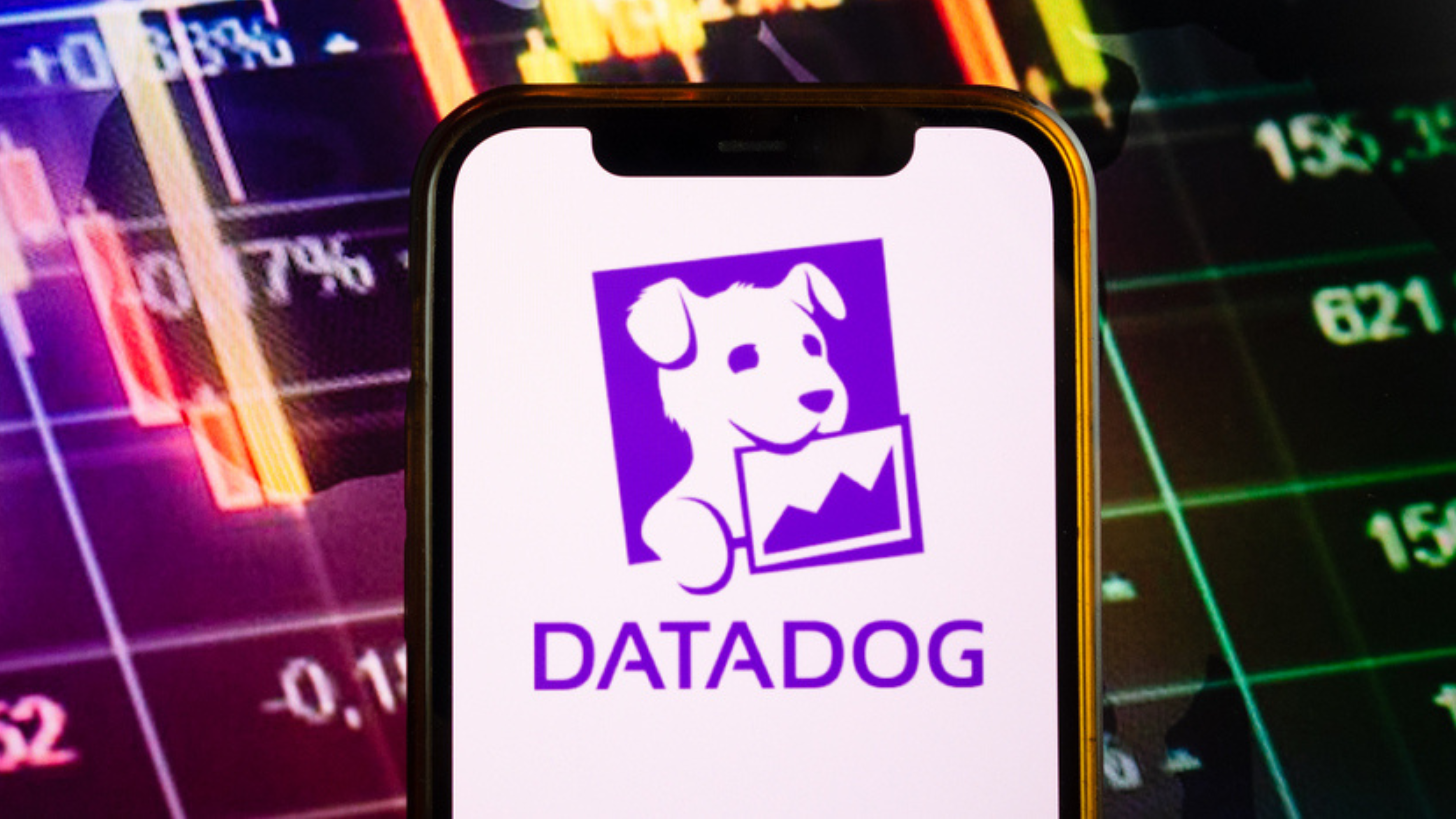 Smartphone displaying logo of Datadog company on stock exchange diagram background
