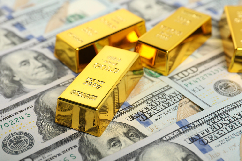 Shiny gold bars on dollar banknotes, closeup
