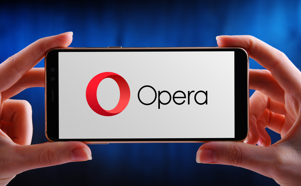 POZNAN, POL - MAY 15, 2020: Hands holding smartphone displaying logo of Opera, a freeware web browser developed by Opera Software - Stock Editorial Photography