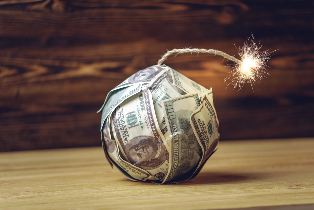 Explosive stock concept photo. Bomb of money like dynamite, hundred-dollar bills with a burning fuse.