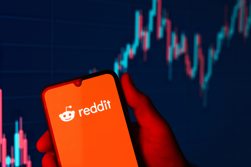 Reddit Logo on smartphone with stock chart 