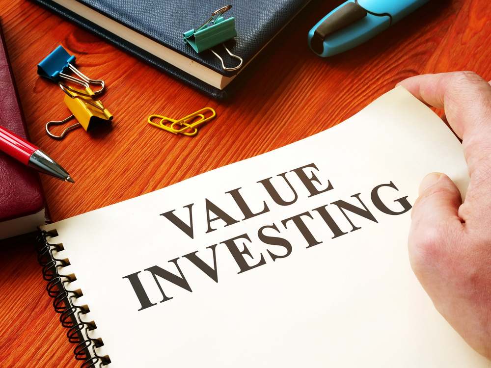Value Investing on a piece of paper sitting on a desk with accessories