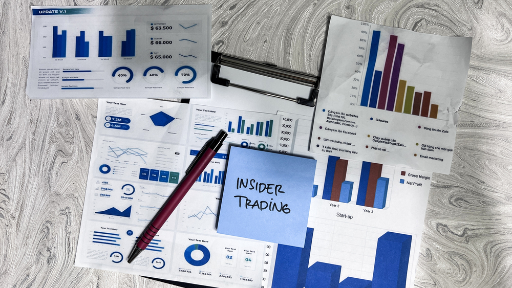 Concept of Insider Trading write on sticky notes isolated on Wooden Table.