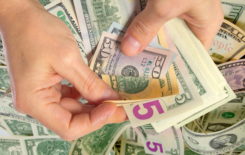 Human hand counting us dollar bills