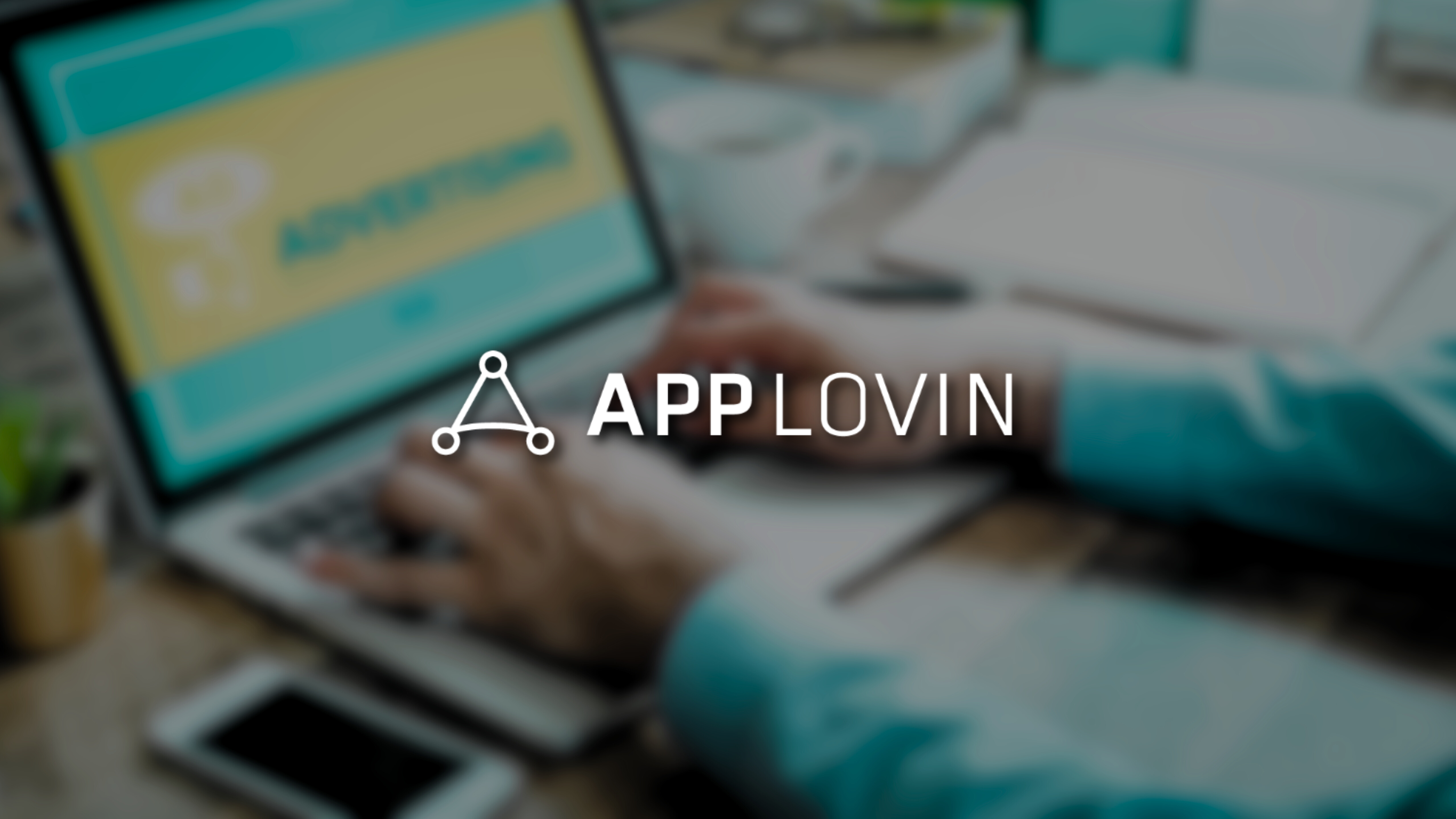 AppLovin logo over digital advertising platform on laptop screen