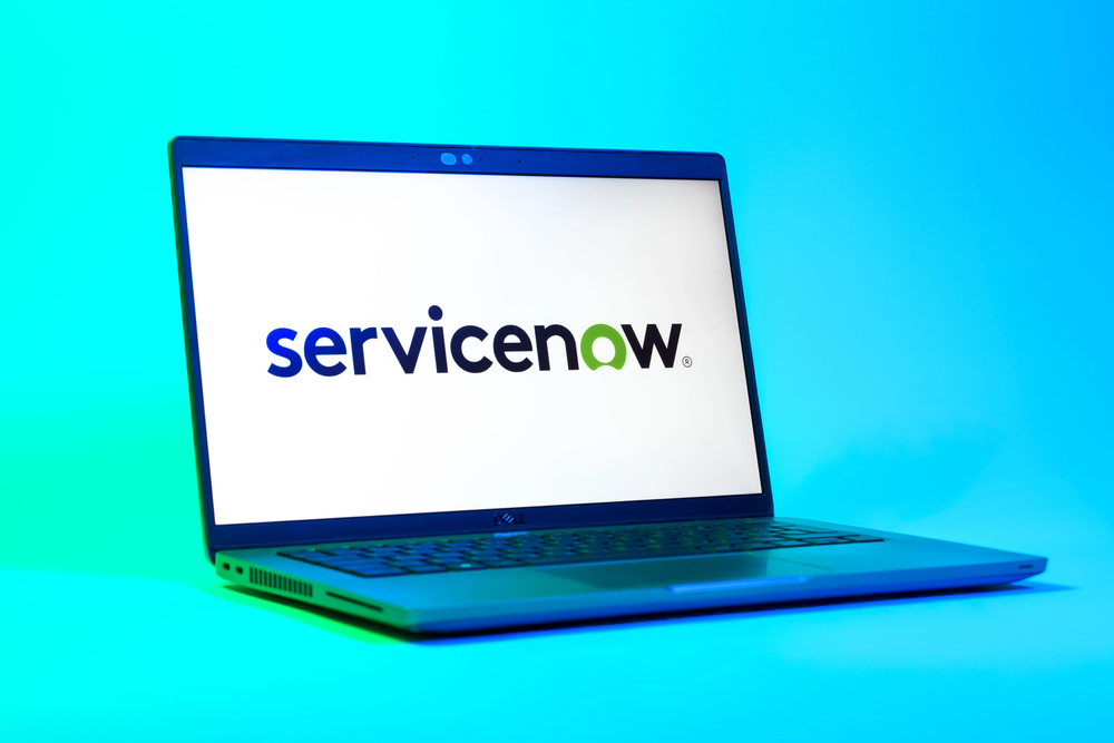 A low-angle view of a laptop displaying ServiceNow logo.