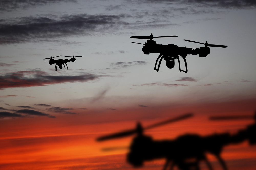 Innovation concept. Silhouette of drone flying on sunset. Heavy lift drone photographing