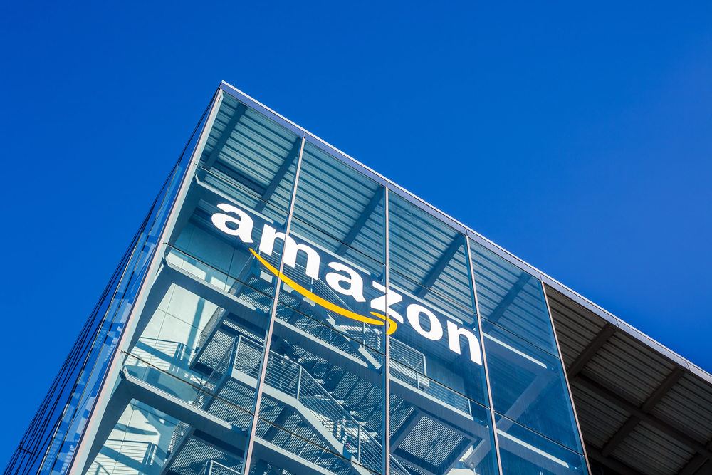 Amazon logo on glass building against blue sky