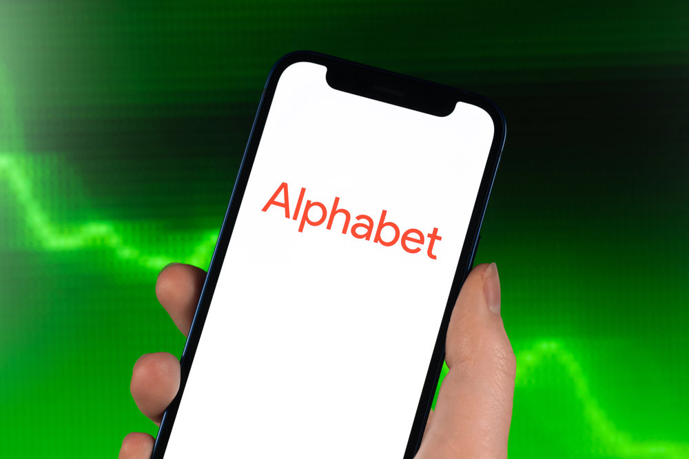 Kharkov, Ukraine - February 11, 2022: Alphabet Inc logo, stock trade on green chart. Google company, technology industry. Finance market background