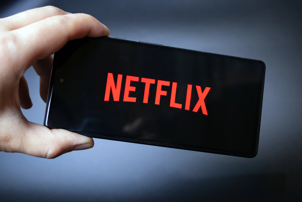 Netflix logo on smartphone screen held by hand. 