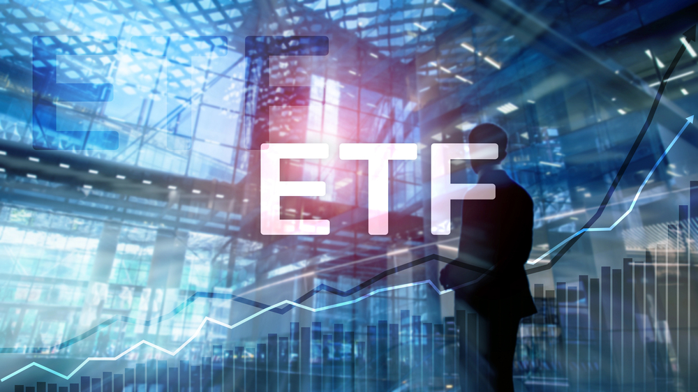 Composite image of a man standing in a glass building, a rising stock chart, and ETF. 