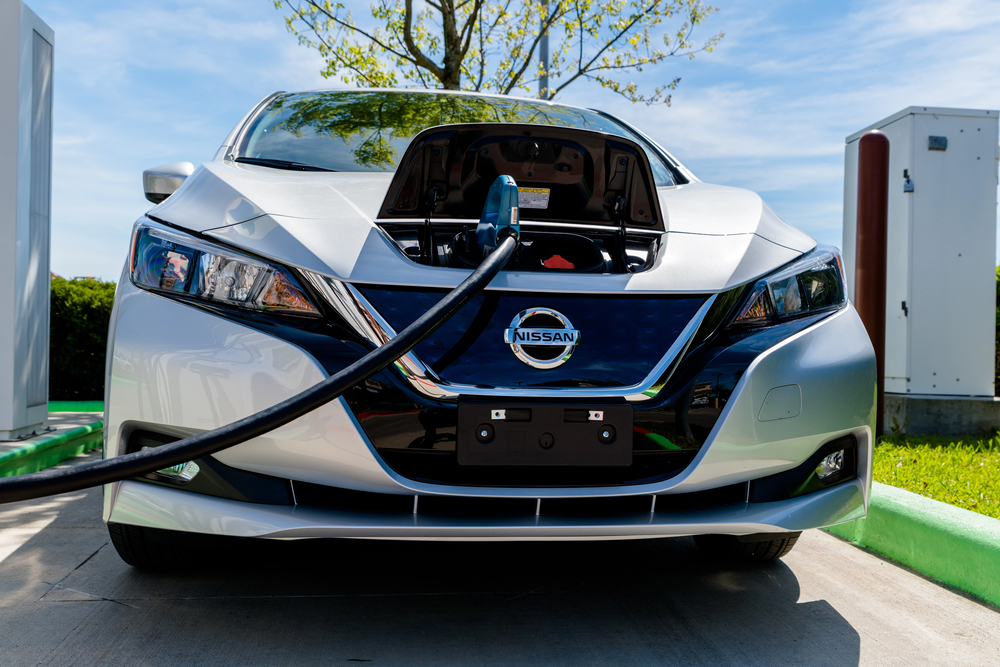 Electric Nissan vehicle at a charging station.