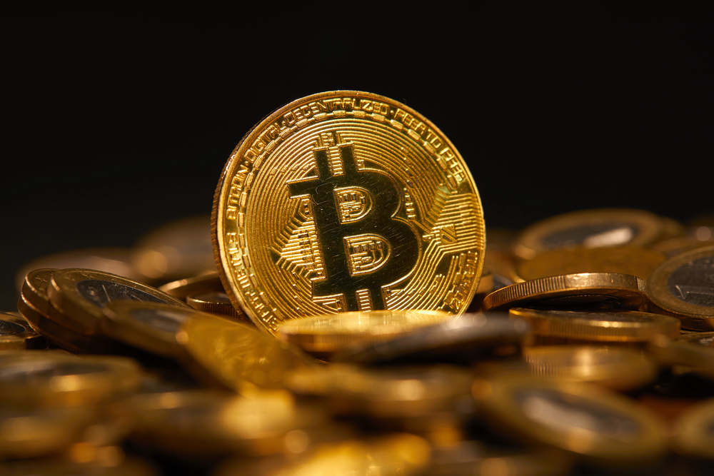 A golden Bitcoin surrounded by coins, symbolizing CleanSpark’s $1.15B raise to expand Bitcoin mining and AI data center operations.