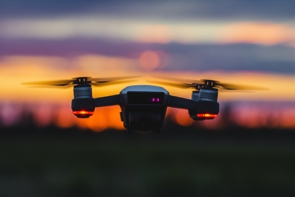 Flying drone on the background of a sunset.
