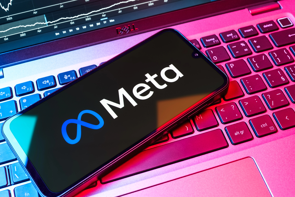 A mobile phone on a keyboard displays Meta logo.