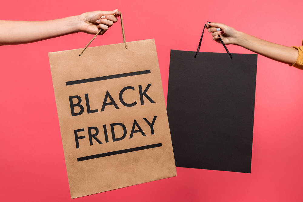 Shopping bags on a pink backdrop. Which retailer will win the 2026 Battle of the Black Friday stocks?