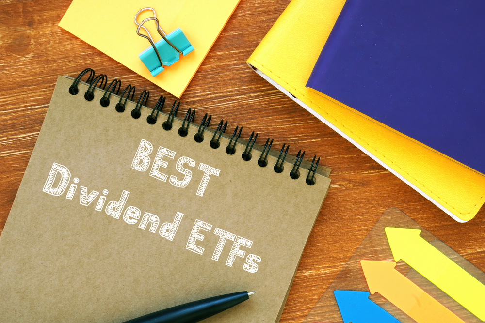 Best Dividend ETFs notebook on desk alongside colorful arrows and office supplies.
