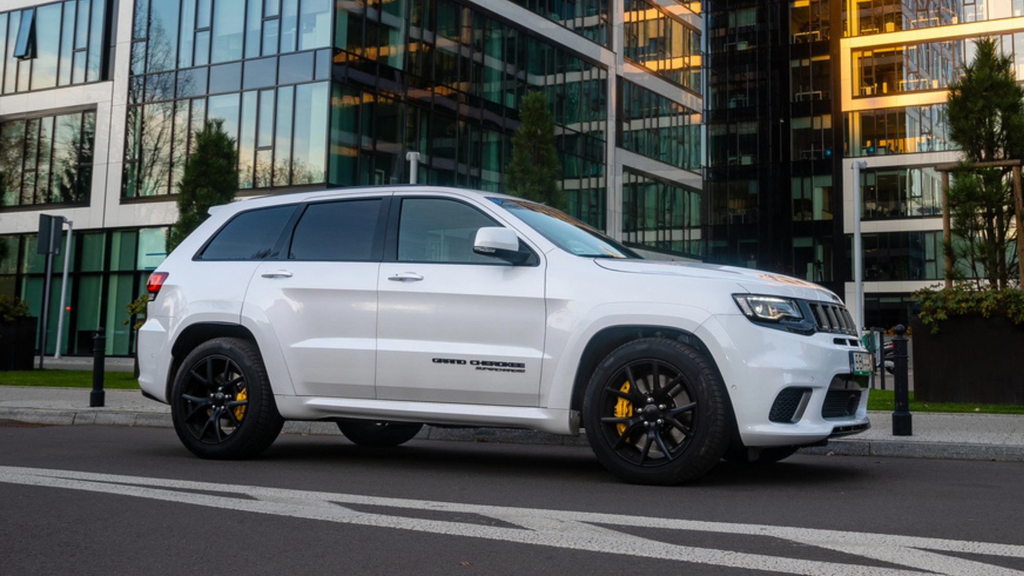 Jeep Grand Cherokee parked on city street. 