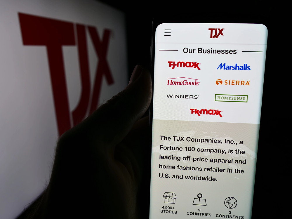 Person holding cellphone with webpage of The TJX Companies Inc.
