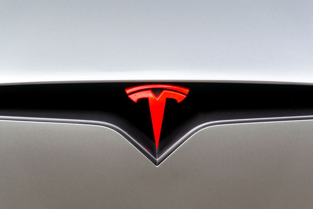 Red Tesla Motors logo on a car.