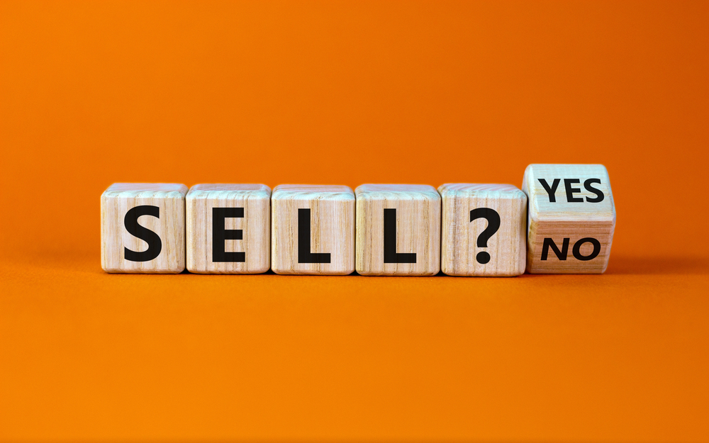 Wooden cubes spelling 'sell' with yes or no block.