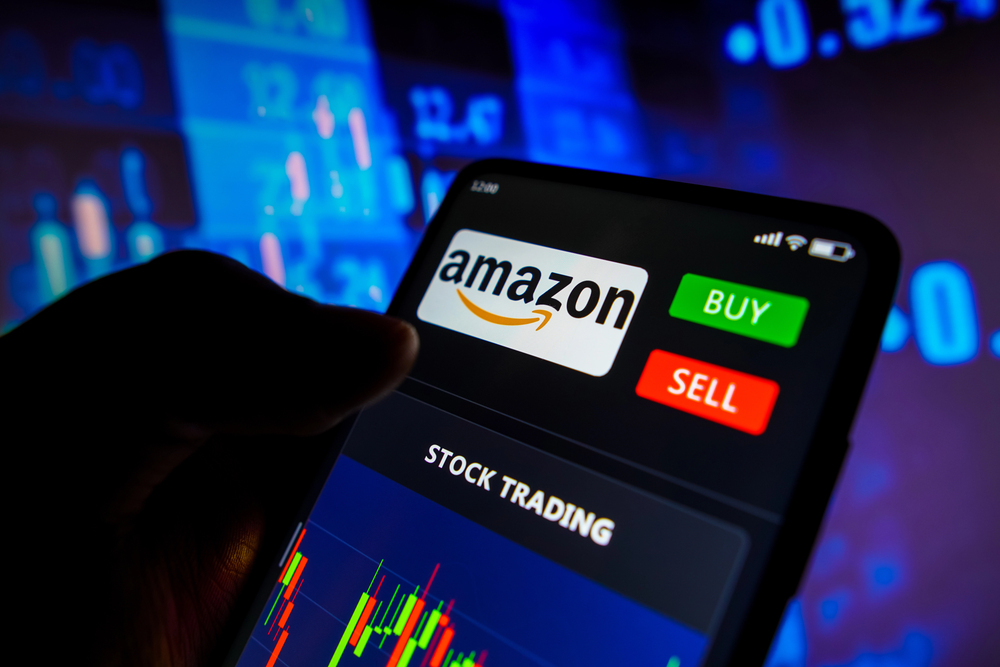 Investor holds smartphone with Amazon stock trading view displayed.