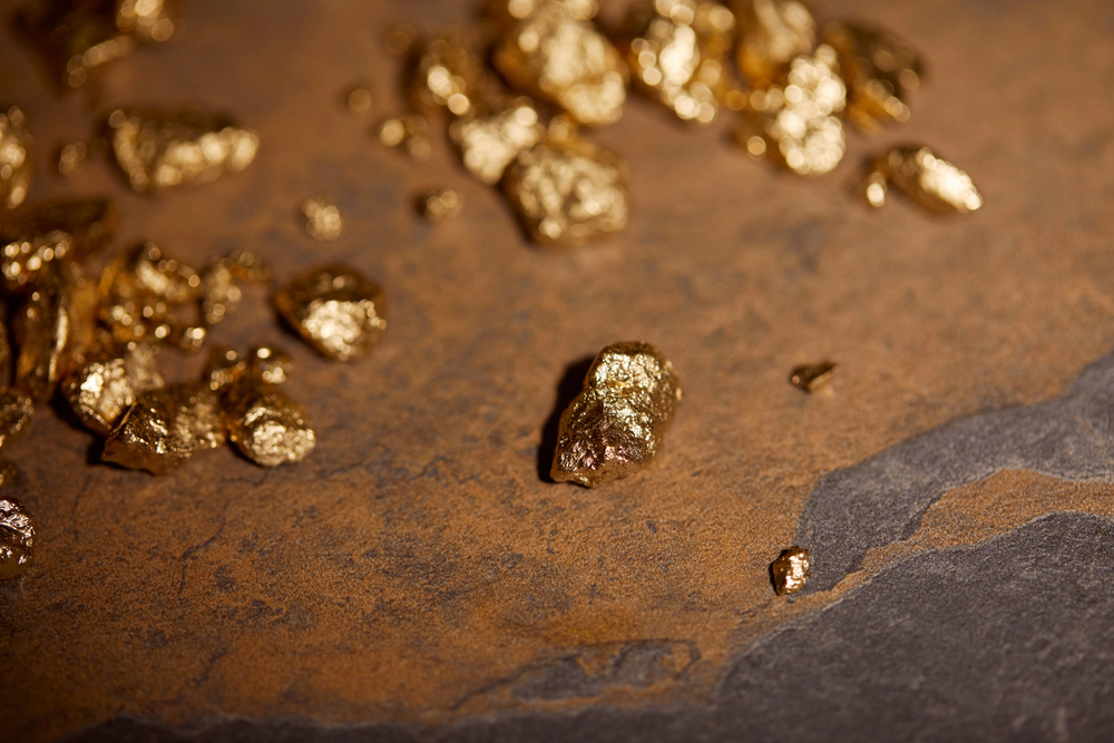 Sensitive focus of gold pieces on grey surface.