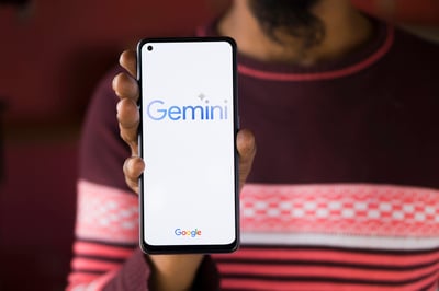 Hand holds google phone with Google Gemini chatbot.