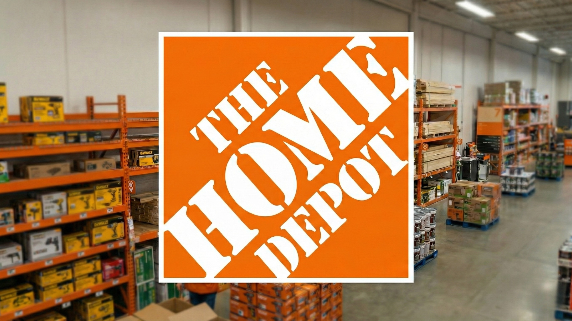 Home Depot store interior with large orange logo sign centered, shelves of tools and lumber visible in background.
