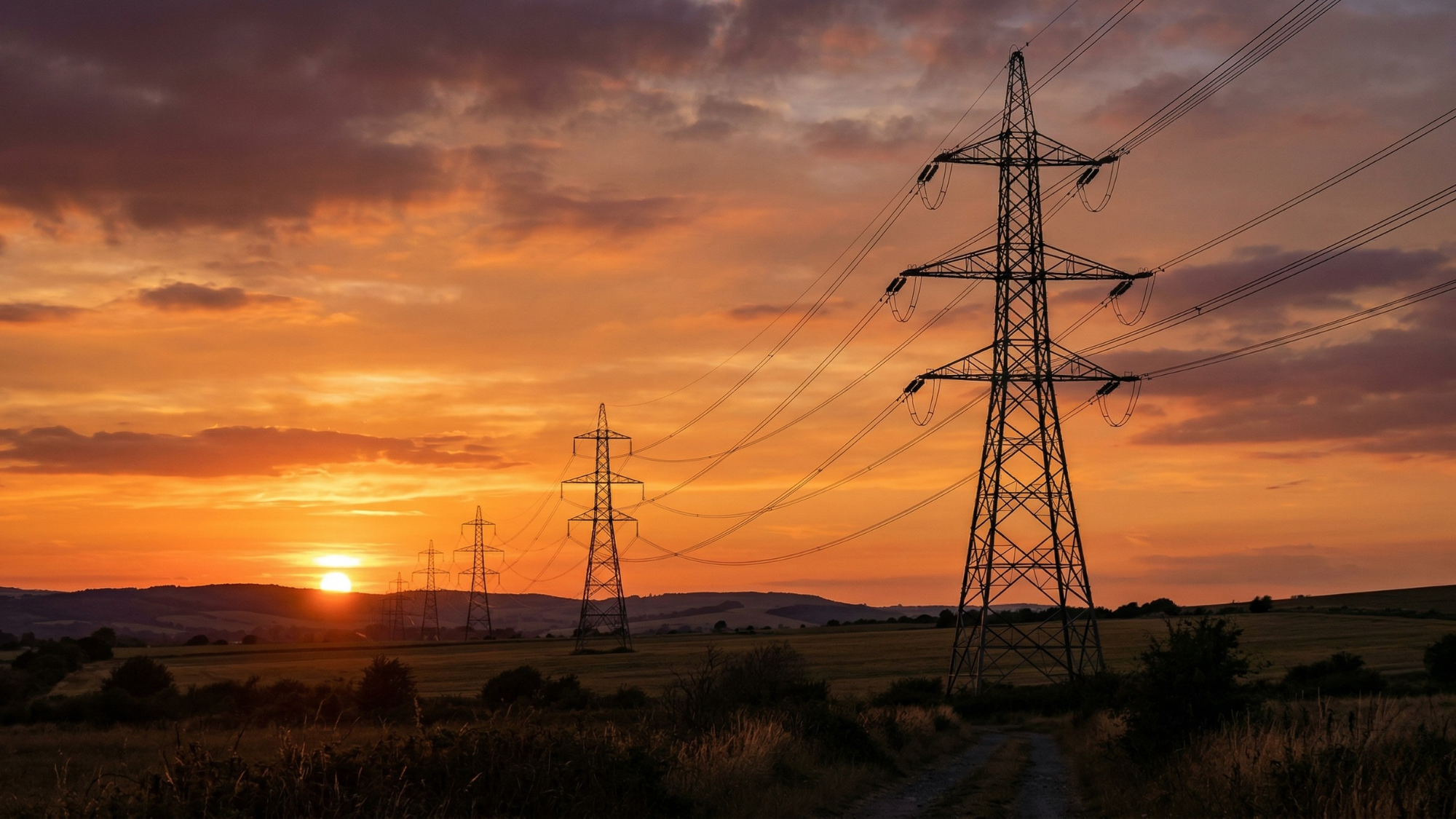 Power lines at sunset underscore surging AI-driven electricity demand and opportunities in energy stocks.