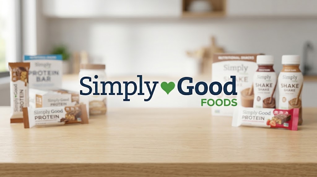 A collection of Simply Good Foods protein bars and shake bottles arranged on a wooden kitchen counter.