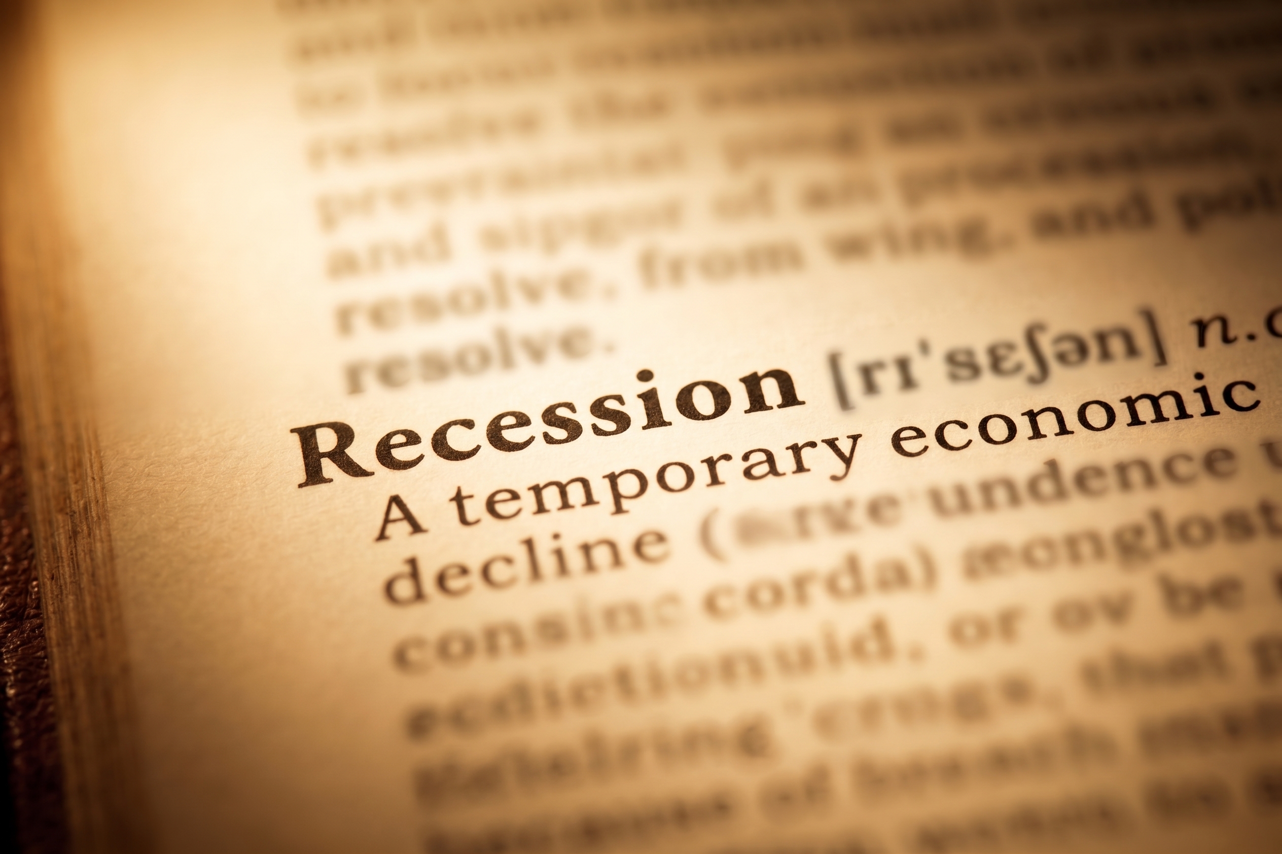 Close-up of a dictionary entry defining the word "Recession" as a temporary economic decline.