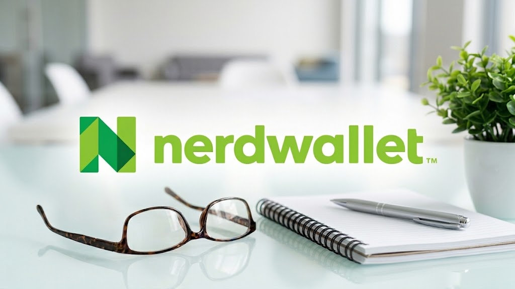 NerdWallet logo displayed over a blurred office desk with glasses, a notebook, and a pen.