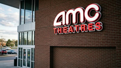 AMC Theatres illuminated signage on the brick exterior of a movie theater building.