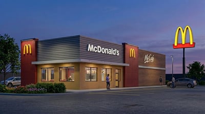 Exterior rendering of a McDonald's restaurant with McCafe signage at dusk.