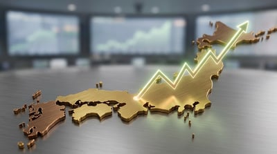 A gold three-dimensional map of Japan with a glowing upward-trending arrow overlay on a desk.