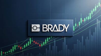 Brady Corporation logo displayed against a dark background with an upward-trending candlestick stock chart.