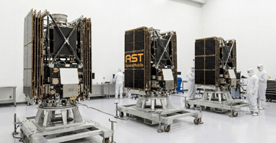 AST SpaceMobile Bluebird satellites displayed in a clean room facility with technicians in white suits nearby.