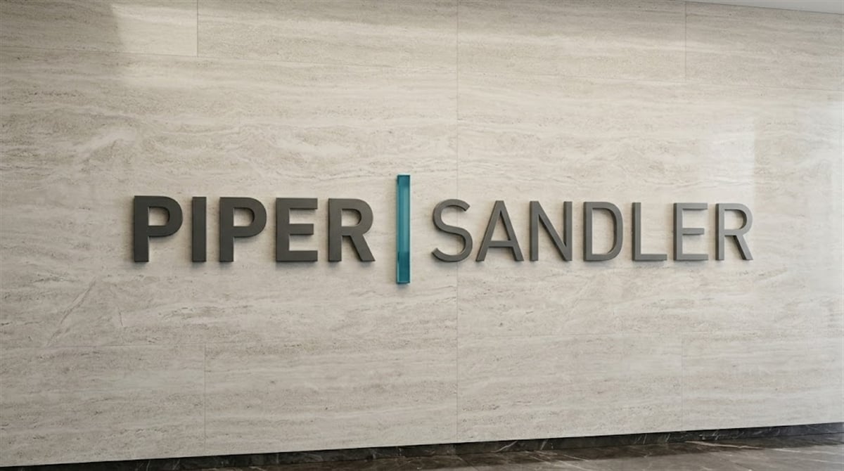 Piper Sandler logo mounted on a marble wall inside a corporate office.