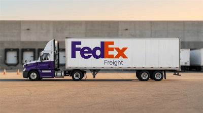A FedEx Freight semi-truck and trailer parked outside a distribution facility.